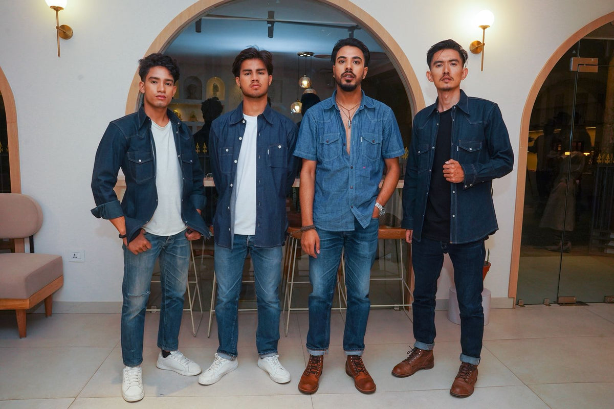 Four men wearing Mith Denim jeans in varying shades from deep raw indigo to lighter faded blue, showing the indigo fading journey