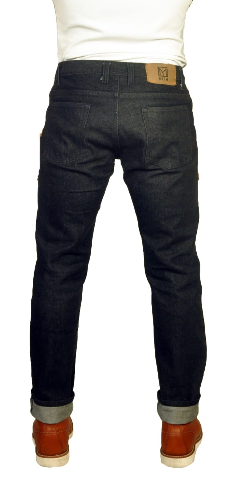 Person wearing dark jeans with a white shirt and brown shoes on a white background - back view