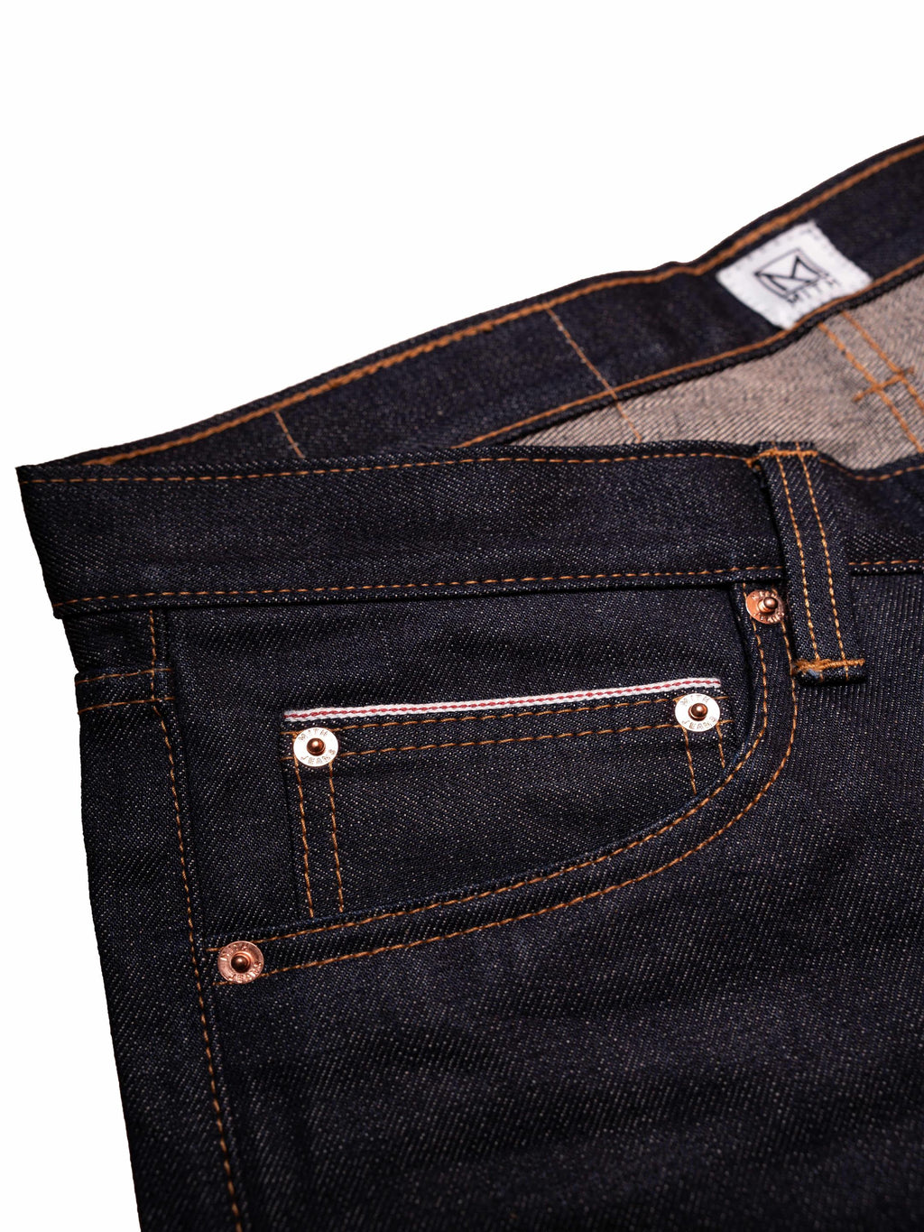 Close-up of 16 oz japanese selvedge denim with stitching details on a white background