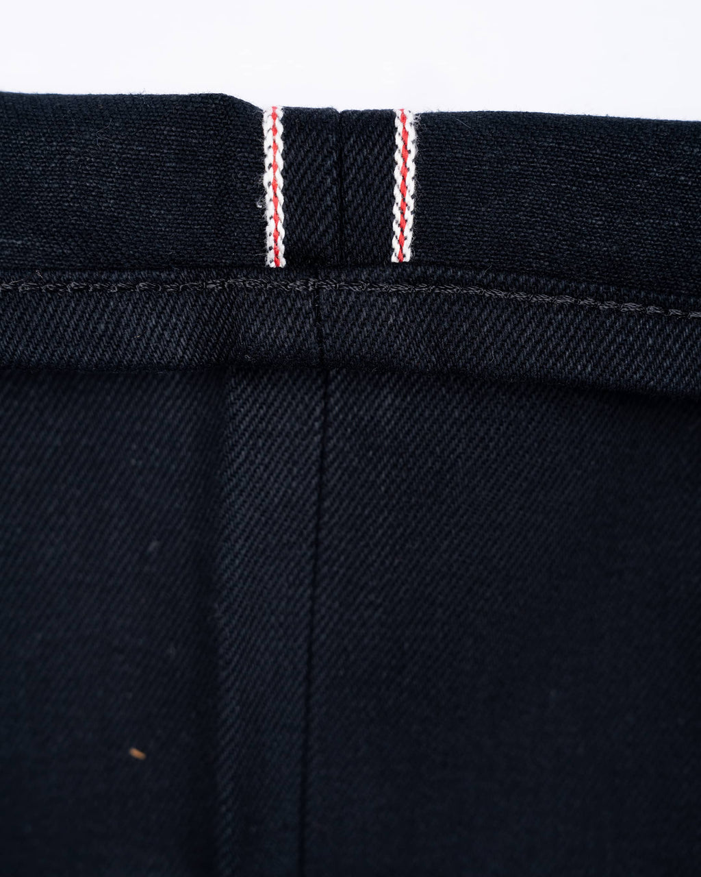 Close-up of 17oz black selvedge denim jeans showing the hem and selvedge id.